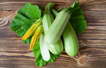 Young zucchini and flowers on a wooden natural background. Ecological food. Vegetarianism.