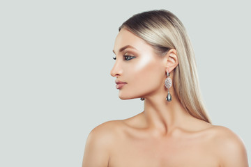 Beautiful Woman Face Closeup. Woman with Perfect Makeup and Pearls Earrings on White Background