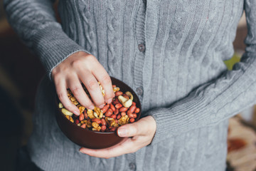 Woman holding a bowl of a mixture of nuts