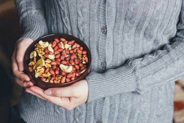 Woman holding a bowl of a mixture of nuts