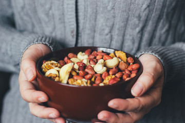 Woman holding a bowl of a mixture of nuts