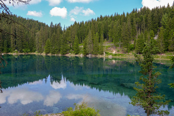 Fototapeta na wymiar Lake Carezza with reflection of mountains in the Dolomites