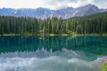 Fototapeta na wymiar Lake Carezza with reflection of mountains in the Dolomites
