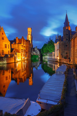 Fototapeta premium Scenic cityscape with a medieval fairytale town and tower Belfort from the quay Rosary, Rozenhoedkaai, at night in Bruges, Belgium