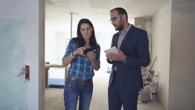 Woman speaking with her architect while using electronics, steadycam shot
