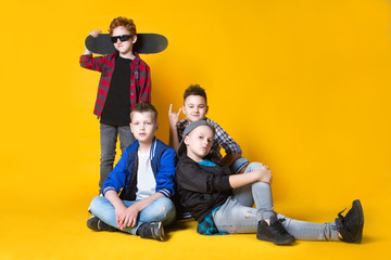 Group fashion cute boy friends together  is looking at camera on a yellow background. friendship, fashion, summer and teens concept. Space for text.