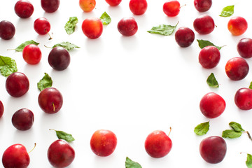 Red and yellow plums pattern on white background. Copyspace