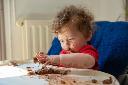 Baby Is Eating A Chocolate Cake