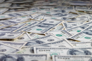 Paper 100 dollar bills spread out on the plane in a chaotic manner