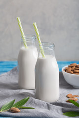Almond milk in two bottles on the blue wooden rustic background