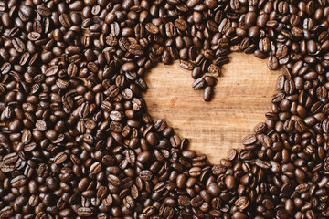 full frame image of fresh dark roasted coffee beans with love shape copy space. can be use as background,wallpaper and backdrop. coffee lovers and addict concept