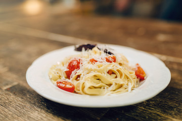 Plate with fresh cooked pasta on wooden table