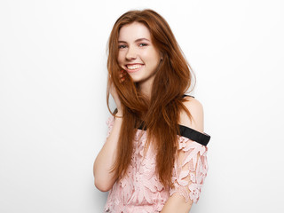 Young beautiful excited woman with bated breath touching her gorgeous natural ginger hair, blank copy space on white background for advertisment or promotional text