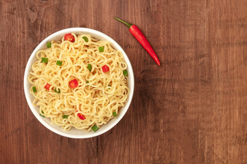Overhead photo of noodles with a chili pepper and copy space