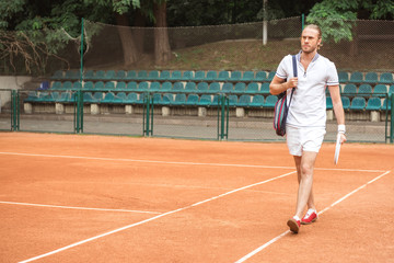 athletic tennis player after training on tennis court