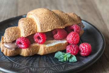 Croissant with chocolate paste and fresh raspberries