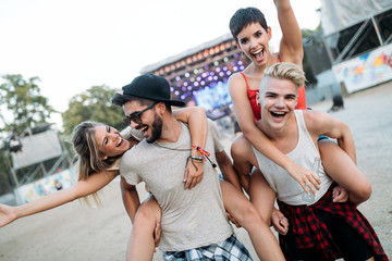 Happy friends having fun at music festival