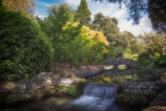 Idyllic picturesque landscape with waterfall and beautiful stone bridge. English river scene.