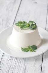 Ricotta decorated with fresh mint on the white plate