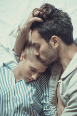 Sweet couple sleeping, boyfriend kisses his tired girlfriend on her forehead, closeness and intimacy