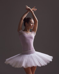 Fototapeta premium Young beautiful ballerina is posing in studio