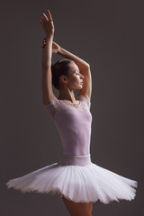Fototapeta premium Young beautiful ballerina is posing in studio