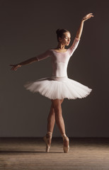 Young beautiful ballerina is posing in studio