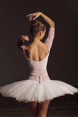 Young beautiful ballerina is posing in studio