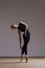 Young beautiful ballerina is posing in studio