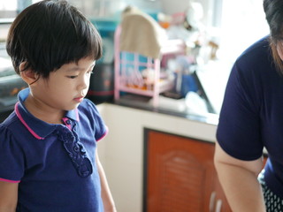 Asian baby girl looking at her auntie preparing cooking ingredients in the kitchen - letting babies...