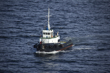 Tug boat, white and black, sailing by the sea 