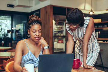 Businesswomen working on laptop in the office cafeteria