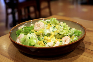 Shrimp salad healthy food on wooden table.