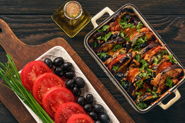Eggplant casserole with mozzarella , tomatoes and olives.