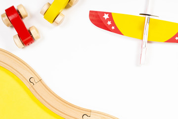 Colorful kids toy plane and wooden cars on white background