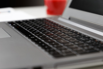 laptop keyboard close-up, white workspace