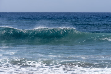 A large wave just on the point of breaking, onto beach