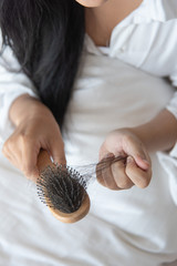 woman looking at her hair for hair loss problem