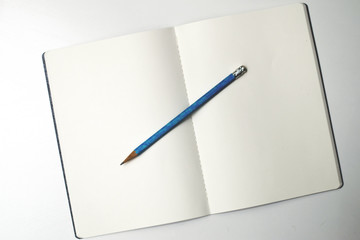 Gładki, niezapisany notatnik z niebieskim ołówkiem, wyizolowany na białym tle