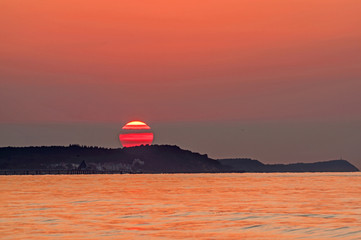 Fototapeta na wymiar Słońce zachodzące nad morskim półwyspem.