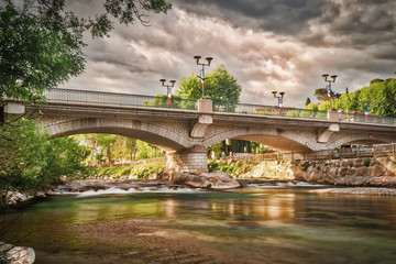 The old bridge over the Le loup River in the French town of Villeneuve Loubet - obrazy, fototapety, plakaty