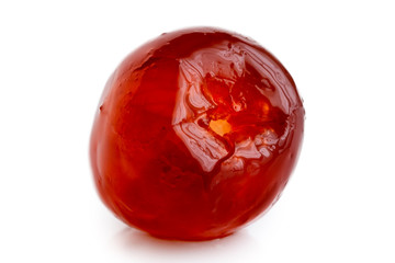 Closeup of a single red glace cherry isolated on white.