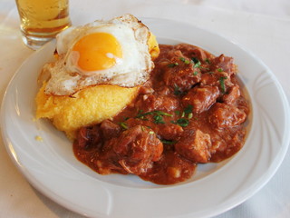 Tochitura Traditional Romanian dish made with beef and pork served with eggs and polenta © sal73it