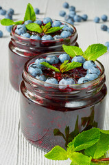 Blueberry smoothies in the glasses with fresh mint on the gray background. Summer detox superfoods breakfast or cold healthy dessert. Close up view