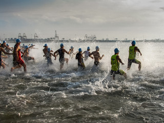 Triathlon competition athletes enter to swim in the sea