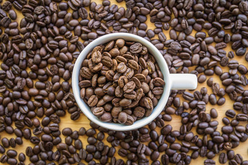Close up of white coffee cup full of coffee beans background with copy space