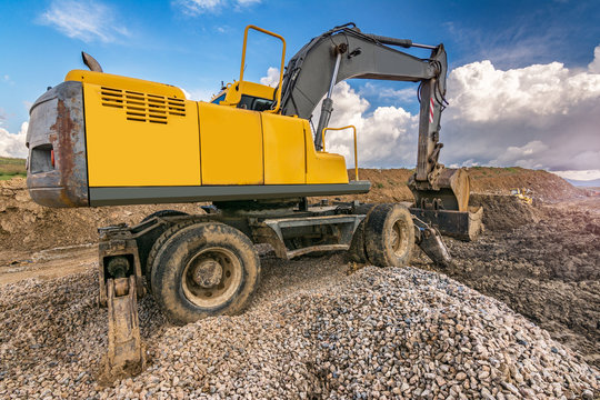 Yellow steamroller on asphalt road in sunlight