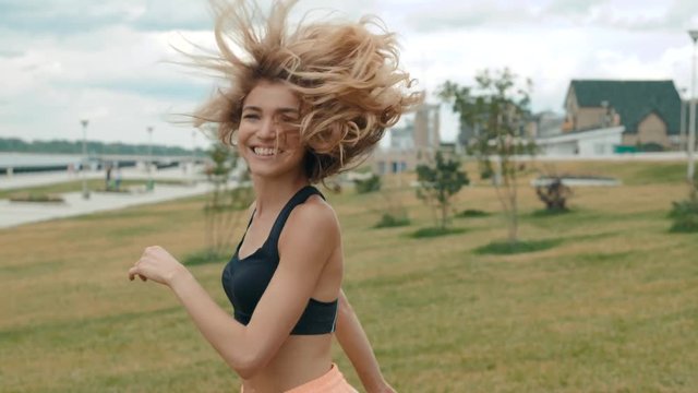 Follow me girl concept. Young pretty happy student model smiling and walking in park. healthy student lifestyle run in city embankment seafront