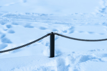 Rectangle metal pole and a rope in deep snow
