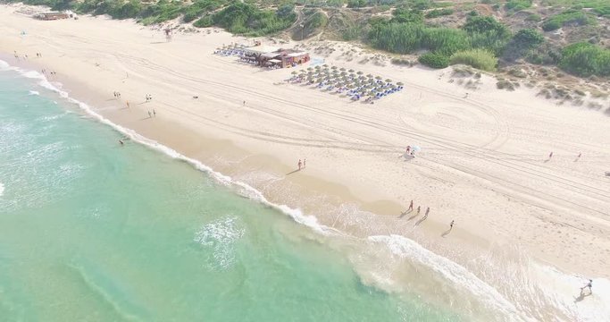 Aerial - Beatiful beach with sun umbrellas and beach restaurant